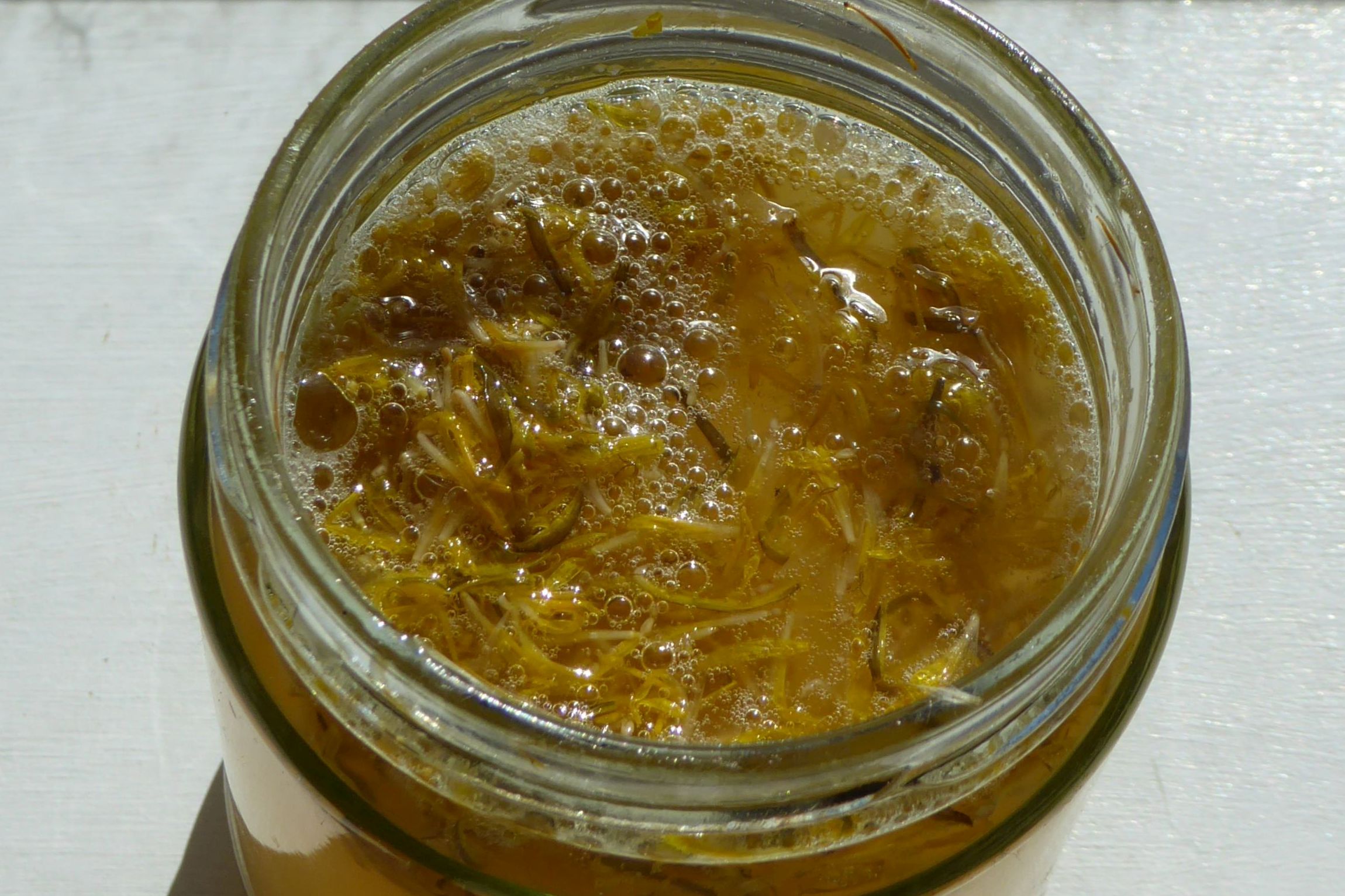Bubbles in jar of dandelion petals